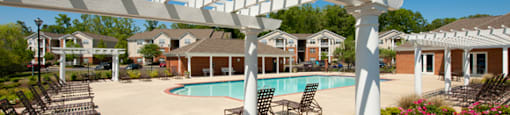 Pergola, tables and chairs overlooking swimming pool and floral landscaping