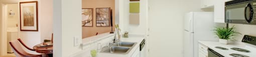 Galley kitchen with white cabinets; separate dining area