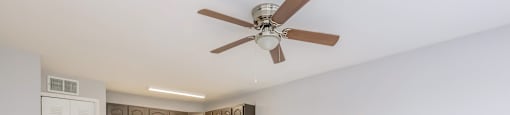 an empty kitchen and living room with a ceiling fan