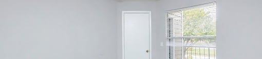 an empty room with carpet and a window