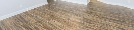 an empty living room with a ceiling fan and a kitchen