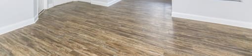an empty living room with a ceiling fan and a window