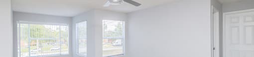 an empty room with striped walls and a ceiling fan