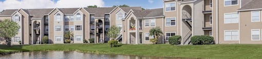 an apartment building overlooking a pond with a duck in it