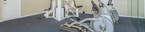 a gym with exercise equipment and mirrors on the wall