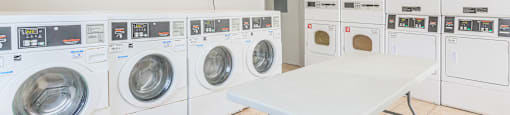 a washer and dryer room with a table and washing machines
