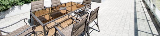 A patio with a table and chairs is surrounded by a building.