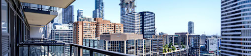 A balcony overlooks a cityscape with tall buildings.