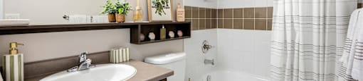 A bathroom with a white toilet, sink, and bathtub.