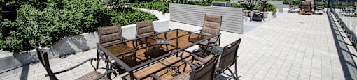 A patio with a table and chairs is surrounded by apartment buildings.
