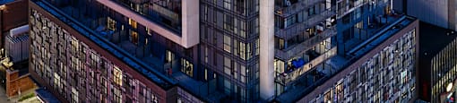 A tall building with a lot of windows is lit up at night.