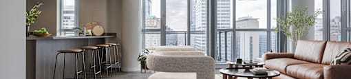 A modern living room with a bar area and a view of the city.