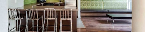 A kitchen with a table and chairs.