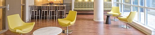 A room with yellow chairs and a bar area.