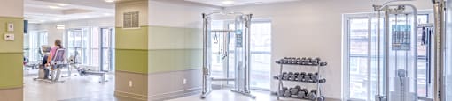 A gym with a bench, weights, and exercise equipment.