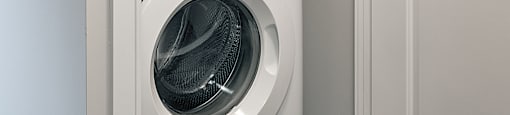 A white front loading washing machine in a laundry room.