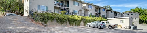 A parking lot in front of a residential building.