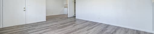A room with a ceiling fan and wooden flooring.