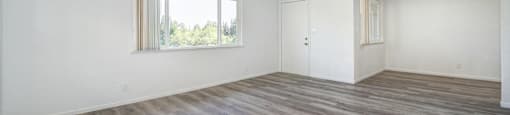 A room with a ceiling fan and wooden flooring.