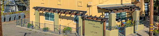 A yellow building with a sign that reads "Almeida Heights" in front of it.