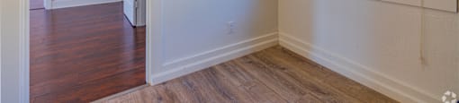 A room with a window and wooden floors.
