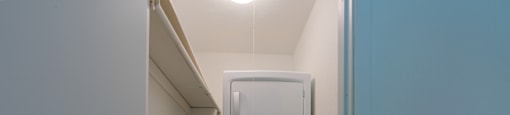 A white washing machine in a narrow hallway.
