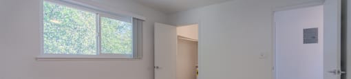 A room with a ceiling fan and a window.