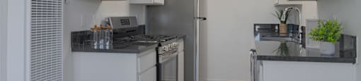 A kitchen with white cabinets and a black countertop.
