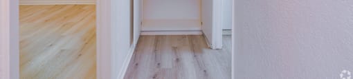 A white closet with shelves and a doorway leading to a hallway.