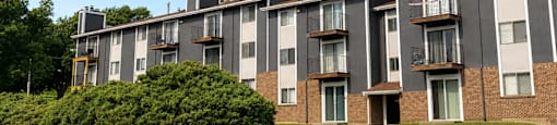 Apartment building with a parking lot in front.