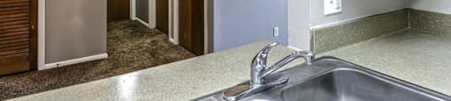 a kitchen with a sink and a hallway with closets