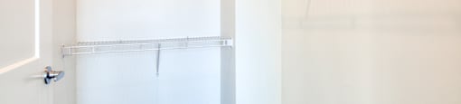 a walk in closet with white walls and a white closet door with a mirrored closet at The Port at East Beach Apartments and Marina, Norkfolk
