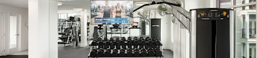 A gym with a row of dumbbells on a rack at The Port at East Beach Apartments and Marina in VA, 23518