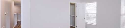 A large, empty room with a carpeted floor and white walls.