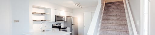 A staircase leads up to a kitchen area.