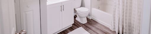 A white bathroom with a toilet, sink, and shower.