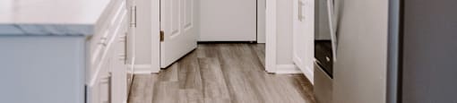 A kitchen with a refrigerator on the right and a sink on the left.