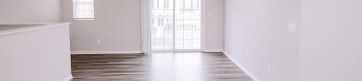A room with a wooden floor and a sliding glass door.