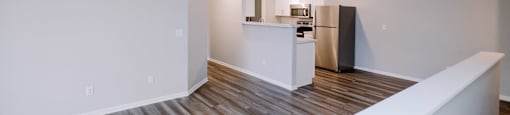 A kitchen area with a white counter and a refrigerator.