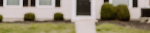 A white house with black shutters and a black door.