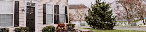 A house with a black door and windows with shutters.