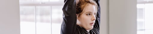 A woman is working out with dumbbells in a gym.