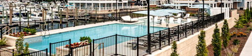 A large building with a pool in front of it at The Port at East Beach Apartments and Marina in Norfolk, VA