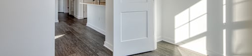 an empty living room with white walls and a white door at The Port at East Beach Apartments and Marina, Norkfolk, 23518