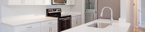 A kitchen with white cabinets and a white countertop.