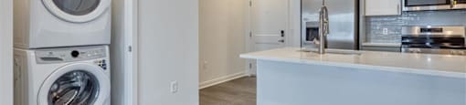 a laundry room with a washer and dryer and a kitchen at The Port at East Beach Apartments and Marina, Norkfolk
