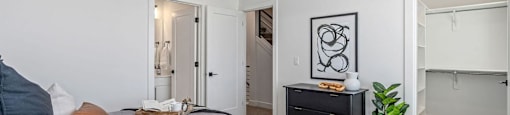 a bedroom with a bed, a dresser, and a closet