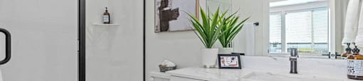 a white bathroom with a shower, a toilet, and a sink