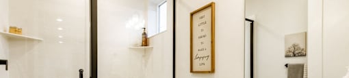 bathroom with a toilet, sink, mirror, and shower