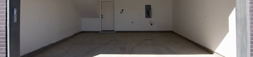 the inside of an empty garage with the door open